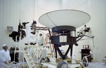 Gli ingegneri lavorano sulla Voyager 2 della NASA al JPL nel marzo 1977, prima del lancio della navicella spaziale di agosto. La sonda trasporta 10 strumenti scientifici, alcuni dei quali sono stati spenti nel corso degli anni per risparmiare energia. Credito: NASA