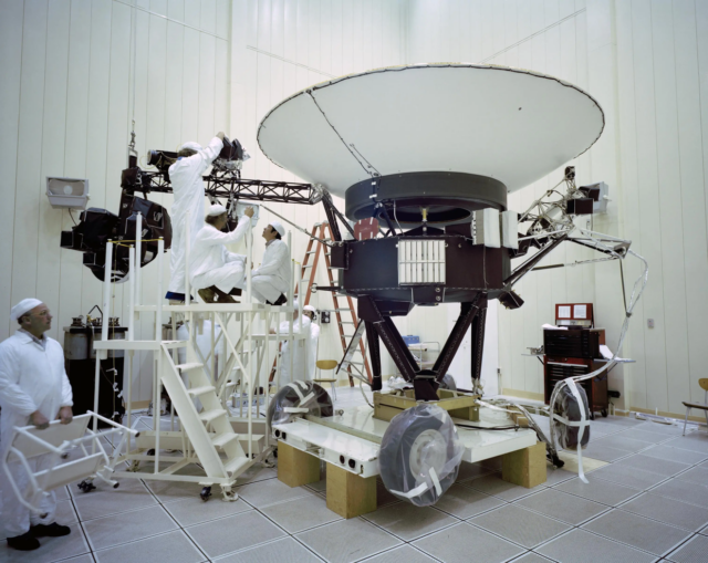 Gli ingegneri lavorano sulla Voyager 2 della NASA al JPL nel marzo 1977, prima del lancio della navicella spaziale di agosto. La sonda trasporta 10 strumenti scientifici, alcuni dei quali sono stati spenti nel corso degli anni per risparmiare energia. Credito: NASA