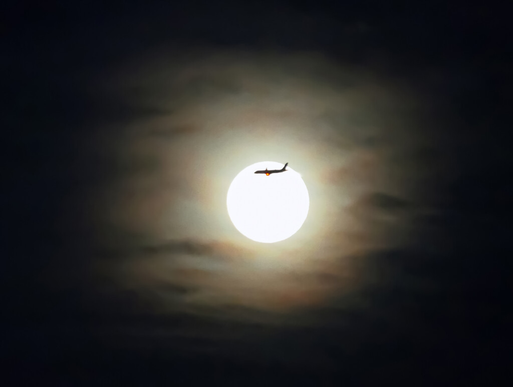 Luma piena del Lupo con aereo e nubi iridescenti