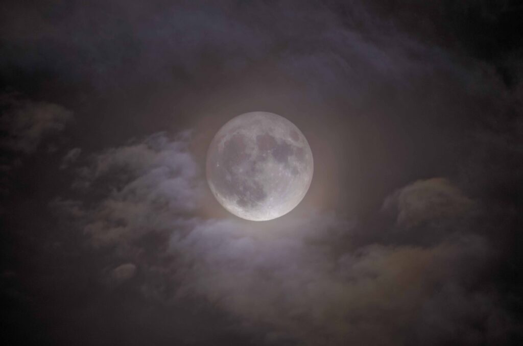 La super Luna che fa capolino tra le nuvole